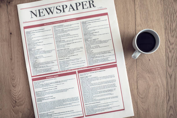 istock Reading newspaper and drinking coffee on wooden background 891569696