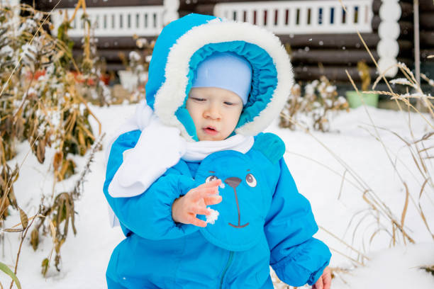 istock Baby boy surprised with first snow holding snow at his hand 891572138