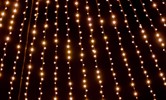 Christmas garlands against black night sky. Christmas lights background