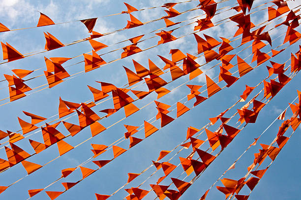 Orange flags against a blue sky stock photo