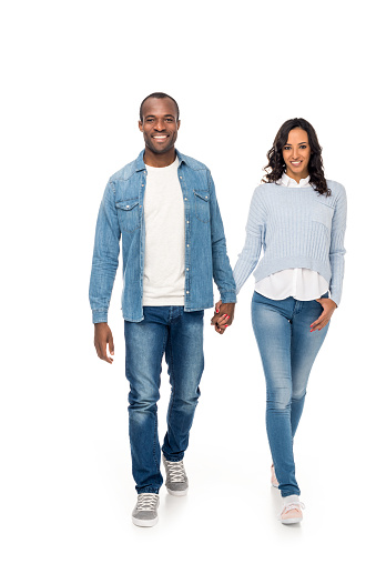 beautiful happy african american couple holding hands and walking together isolated on white