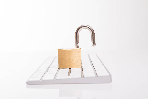 istock Open steel padlock lying on a white computer keyboard in a low angle view in a concpet of privacy and online security 891589114