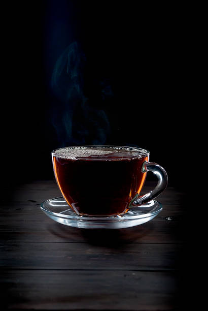 istock Cup of  tea on black   background 891600386