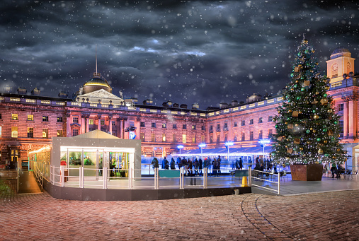 The Somerset House in London with a ice rink and christmas tree during winter with snowfall