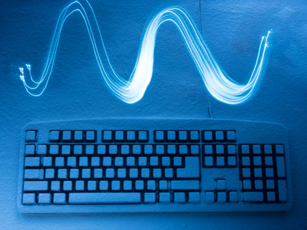 istock computer keyboard covered with snow illuminated by blue light with traces in the form of a wave from drawing by light 891602048