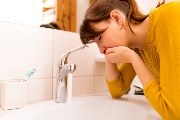 Young vomiting woman near sink in bathroom Young vomiting woman near sink in bathroom nausea photos stock pictures, royalty-free photos & images