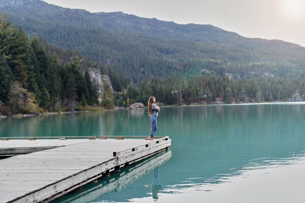 istock Young woman enjoying lake and mountain view 891609794