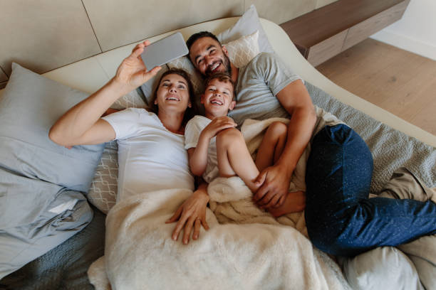 istock Family taking selfie on bed at home 891624786