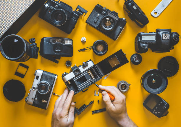 istock Human Hands Repair Broken Film Camera, Top View 891624894