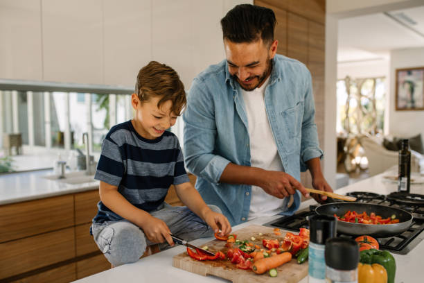 father and son preparing food in kitchen - cozinha imagens e fotografias de stock