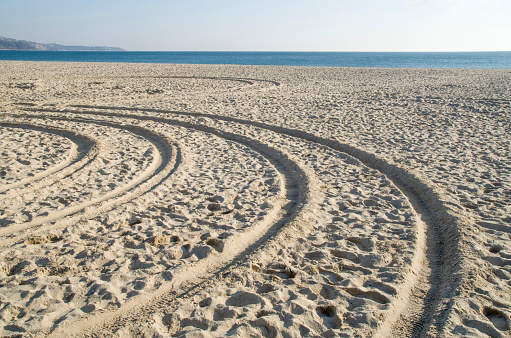 Turn traces of tires in sand in sunny day