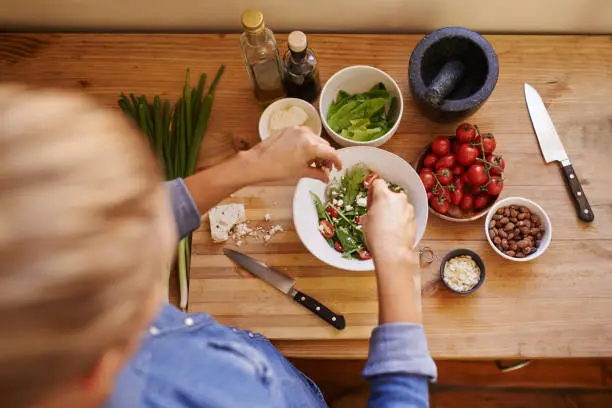 Cropped shot of an unrecognizable woman using ingredients to make a healthy salad