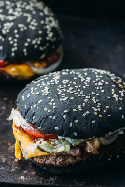 istock Black burger with meat and onion rings 891635460