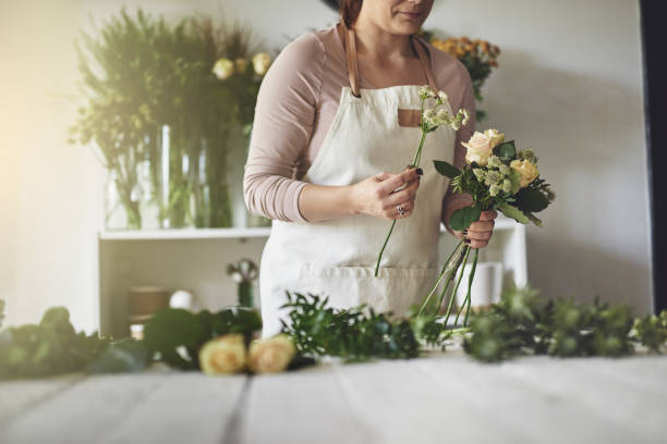 istock Female florist working in her flower ship making a bouquet 891641722