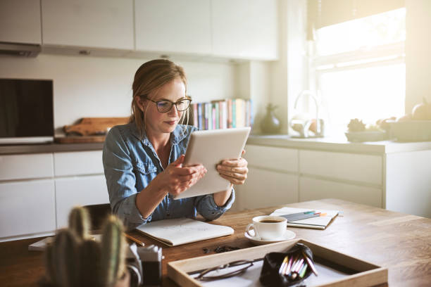 istock Young woman working from home with a digital tablet 891643978