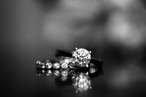 Diamond Ring on Glass Table Wedding Ring, diamond ring, bokeh, black and white, diamond gemstone photos stock pictures, royalty-free photos & images