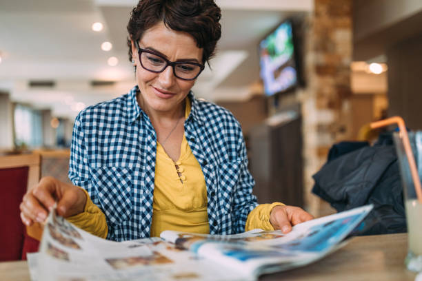 mujer leyendo una revista - newspaper glasses the media reading fotografías e imágenes de stock