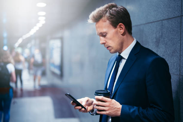 istock Businessman reading messages while waiting for a subway train 891653074