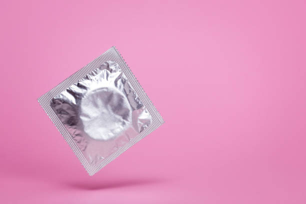 Сondom packed in air levitation on a pink background. Empty space for text. mock-up Сondom packed in air levitation on a pink background. Empty space for text. mock-up condom photos stock pictures, royalty-free photos & images