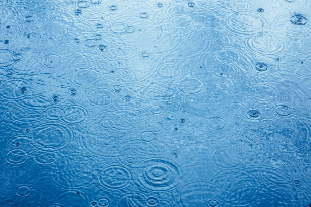 Rain drops background Rain drops on water puddle stock pictures, royalty-free photos & images