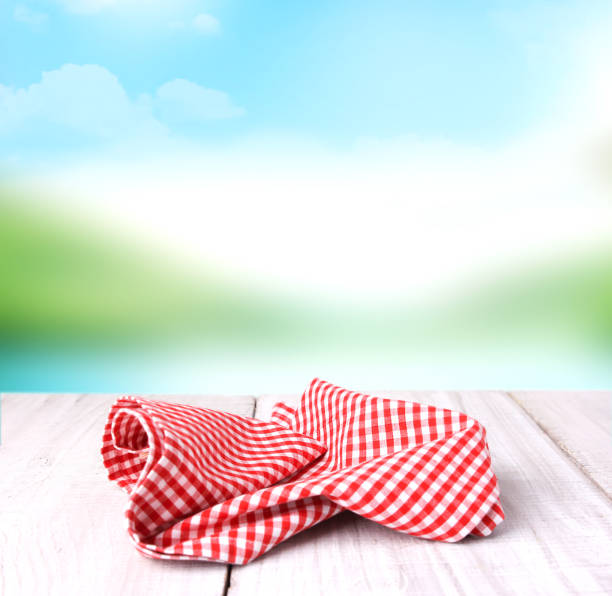istock Red checkered picnic cloth on wooden table empty space background. 891690700
