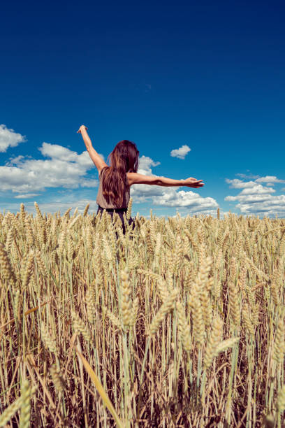 istock women in corn field with blue cloudy sky 891690706