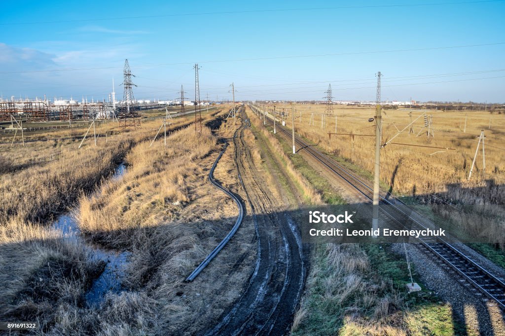 Plot railway. Top view on the rails. High-voltage power lines for electric trains Plot railway. Top view on the rails. High-voltage power lines for electric trains. Agricultural Field Stock Photo