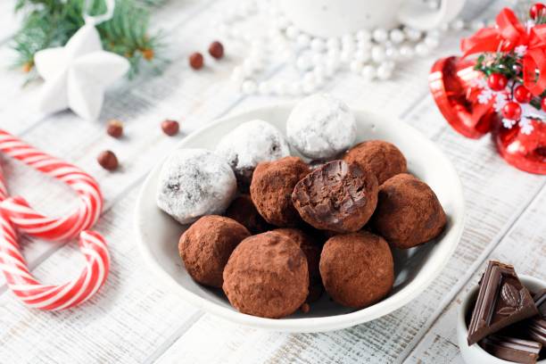 istock Homemade chocolate candy truffles with candy canes on white table. 891694568
