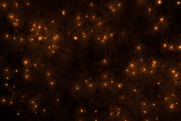 istock Warm dark orange gold sparkles on dark background, horizontal. 891695258