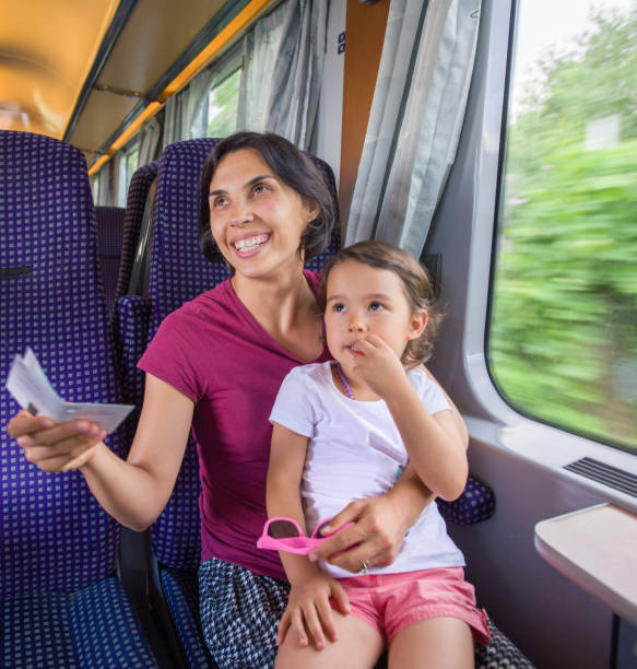istock Woman and daughter having her ticket checked by the train conductor 891698732