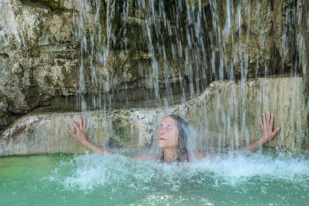 beatitudine della cascata calda - waterfall zen like women meditating foto e immagini stock
