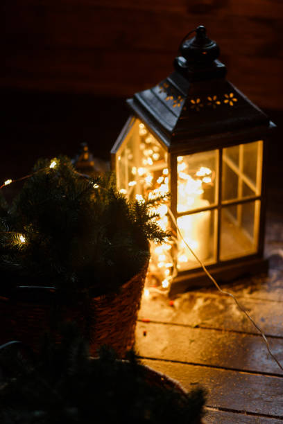 istock Lantern with led light garland inside. In dark room. Beautiful evening lights. 891707978