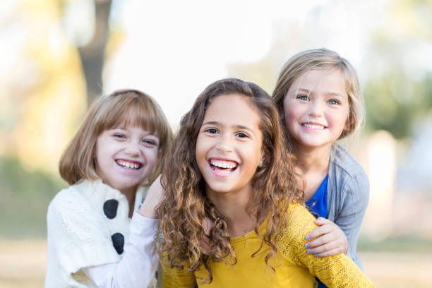 istock Portrait of three sisters outside on a sunny day 891713064