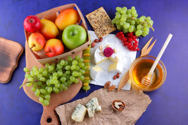 istock Cheese with green grapes berries of viburnum and peanuts 891713156