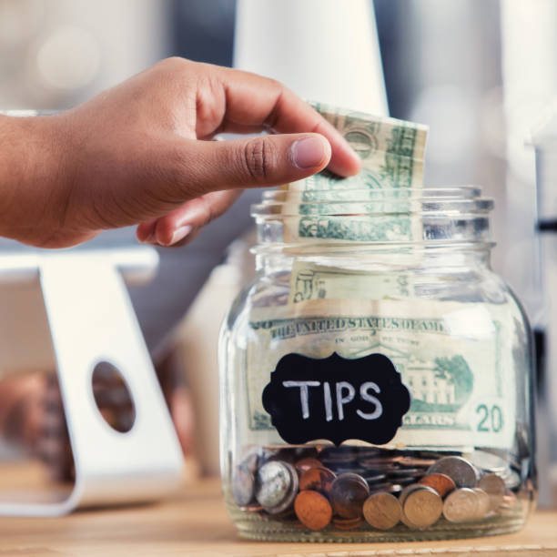 istock Coffee shop customer places cash in tip jar 891713436