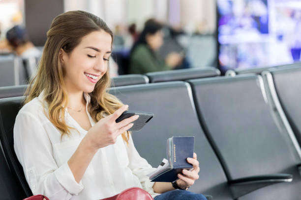 Young woman texts friend before international flight