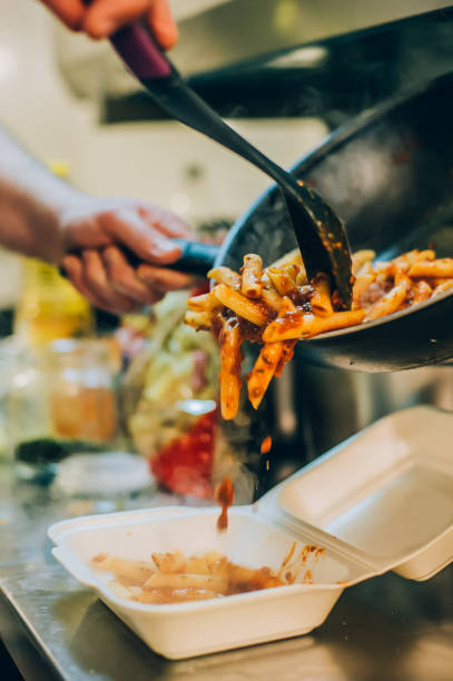 chef-koch gießt spaghetti in fast-food-kunststoff lieferung-pack - cooking oil plastic oil fork stock-fotos und bilder