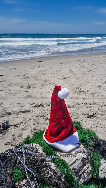 istock Santa Hat at the beach with miniature Santa Klaus 891746122