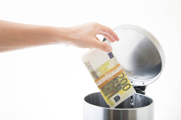 istock throwing away euro in waste can 891759026