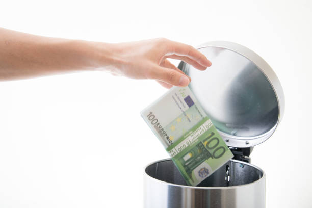 istock throwing away euro in waste can 891763166