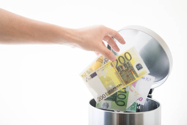 istock throwing away euro in waste can 891763636