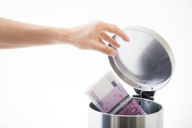 istock throwing away euro in waste can 891765786