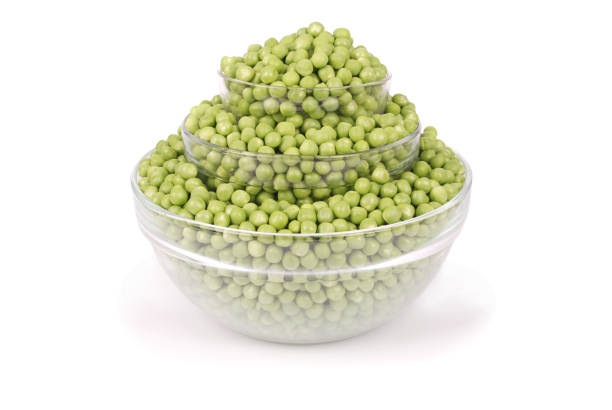 istock Fresh green peas in bowl isolated on white 891765848