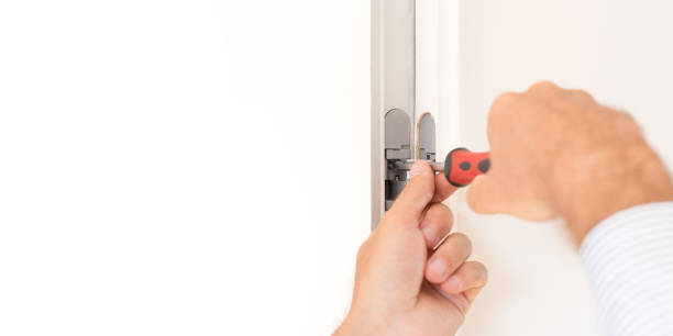 istock Repairman fixing a door hinge, construction and architecture concepts 891772628