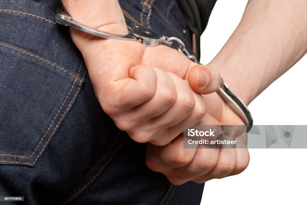 Handcuffs. hands with handcuffs Arrest Stock Photo