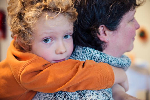 istock Cute strawberry blond kid hiding in mother's neck. 891795172