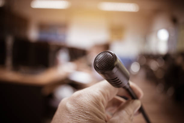 Microphones in seminar room, talking speech in conference hall light with microphone and keynote. Speech is vocalized form of communication humans, Blurred of audience in meeting room, vintage tone