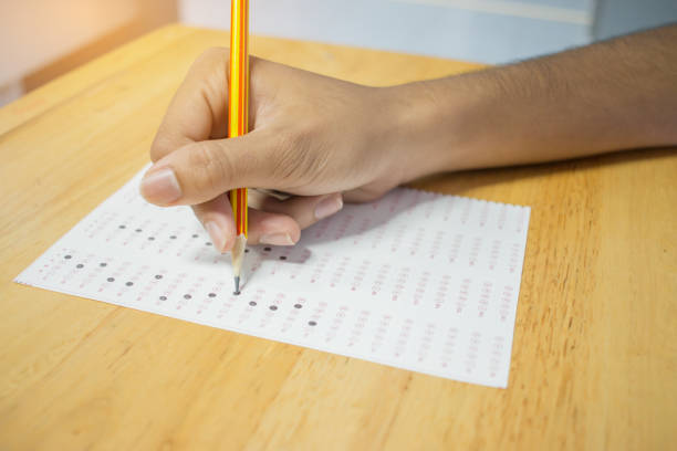 istock Top view of School Asian students taking exams writing answer optical form with pencil in university classroom, view of having exams in class on seat rows, Education test and literacy concept. 891800710