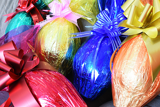 A traditional dyed colourful Easter egg in a basket with feathers in Poland called pisanka or kroszonka in Europe