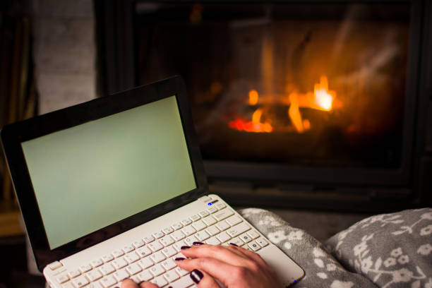 istock Girl using laptop by the fireplace 891807574